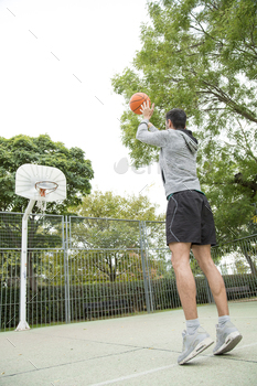 Basketball player training alone in a court