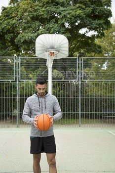 Man holding a basketball ball outdoors