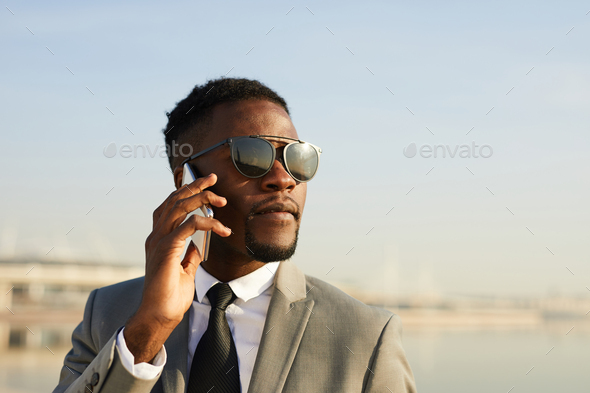 Serious cool manager talking on phone