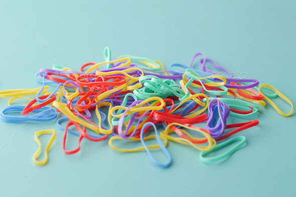 Colorful rubber bands on green background Stock Photo by