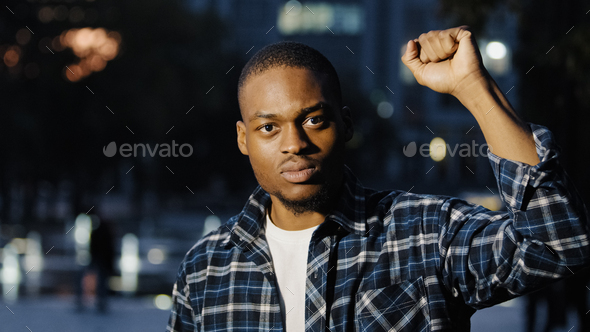 African american man hold fist in air. Social male activist speak outdoors in evening city