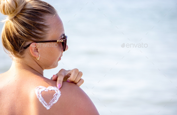 painted heart on the girl's back with sun cream. - Stock Photo - Images