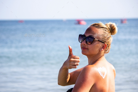 painted heart on the girl's back with sun cream. - Stock Photo - Images