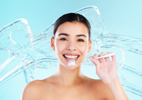 Oral health is wealth. Shot of a young woman brushing her teeth against a studio background.