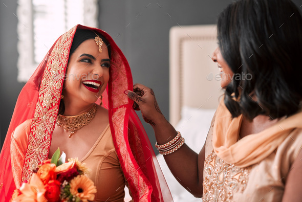Shot of a young woman getting getting ready for her wedding with her bridesmaid - Stock Photo - Images