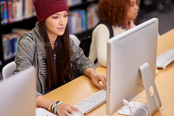 Time for facts and theories. Shot of students working on computers in a university library. - Stock Photo - Images
