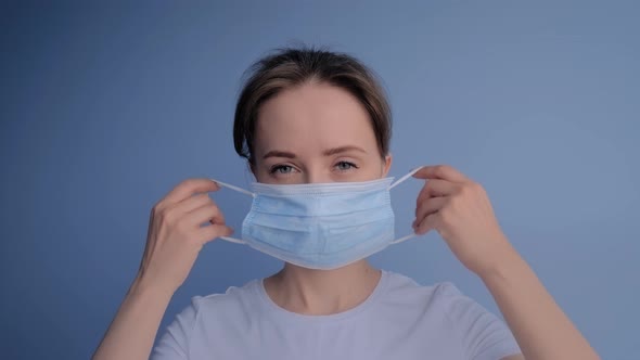Portrait of Woman Putting on Face Mask, Looking at Camera: Slow Motion, Close Up