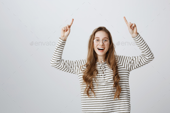 Raise your hand if you have idea. Studio shot of positive attractive young woman with transparent