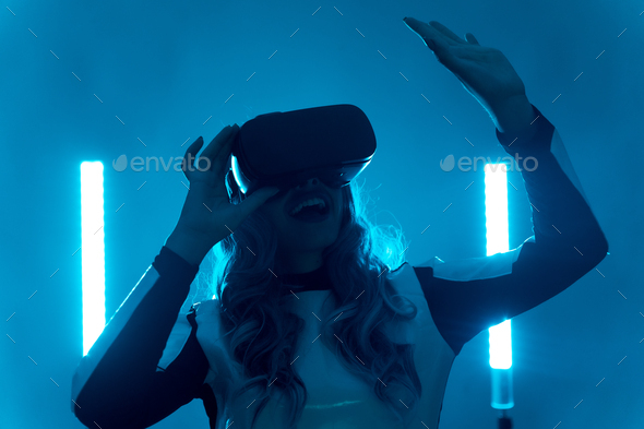 Woman wearing virtual reality glasses, futuristic concept, silhouette of a young woman from future