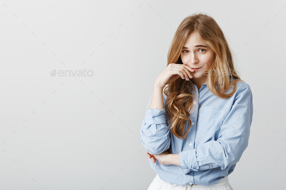 Girl making flirty face, trying to charm boyfriend. Cute timid female student in blue-collar shirt