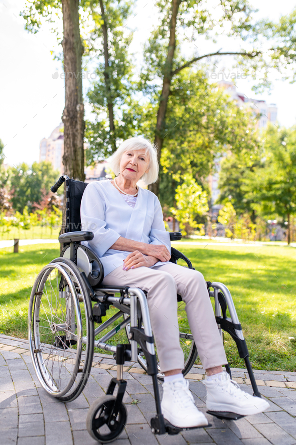 Senior woman with disability on wheel chair at the park
