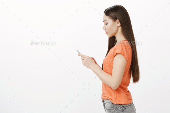 Serious businesswoman using app to contact customer. Profile portrait of focused charming european