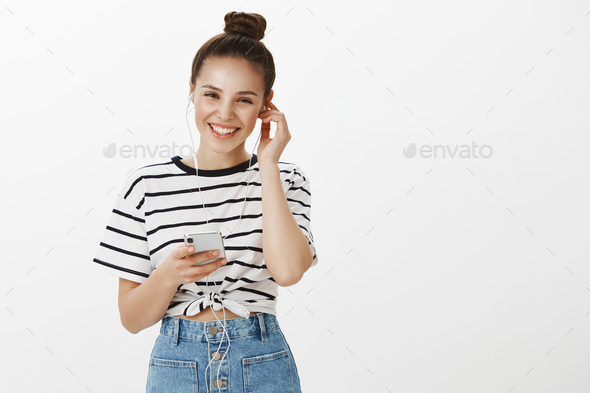 Girl listening voice mail, pleased to receive greetings. Happy good-looking european female student