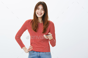 Woman lending phone for friend to call mom. Portrait of friendly-looking happy young female student