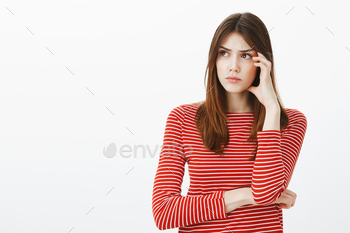Keep thinking and ideas will come. Portrait of focused attractive smart woman in striped clothes