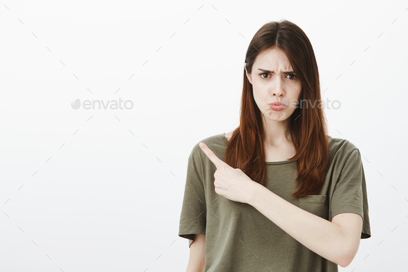 Offended girl tells friends who insulted her. Portrait of upset unsatisfied woman, frowning and