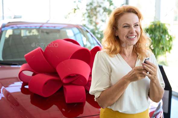 Beautiful woman holding the key to a new car in her hands