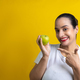 Latin woman with green apple in hand pointing with index finger, on yellow background - PhotoDune Item for Sale