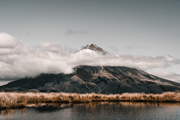 soft vegetation surrounding the lake and the impressive mountain in a beautiful nature landscape - Stock Photo - Images