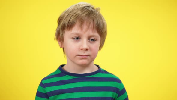 Closeup Portrait of Tired Little Boy Yawning at Yellow Background alt