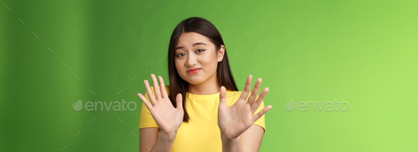 Modest cute insecure timid asian girl waving hands no gesture, step back, smirk, cringe aversion