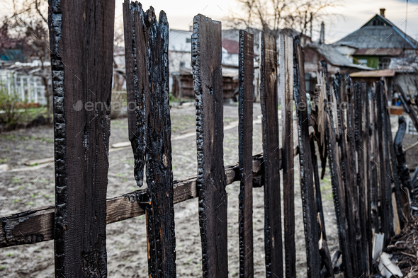 Burnt fence boards after a fire in a private house.