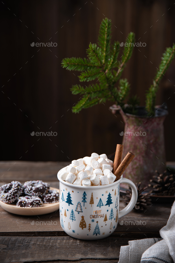Christmas cup of cacao and marshmallow with cinnamon on an old brown wooden table with cookies