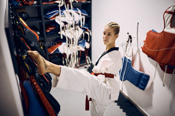 Female martial artist with disability dressing up in locker room at health club.