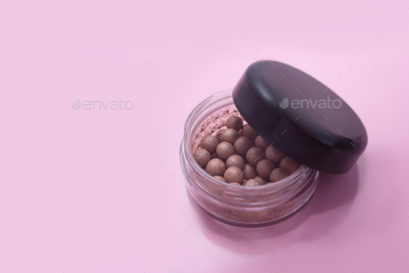 Close up of facial powder pearls in an opened powder box.