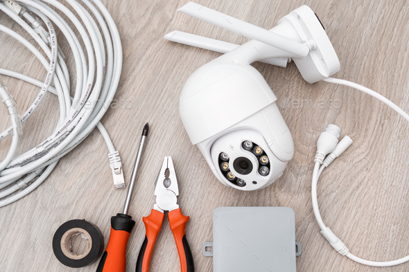 Cable, screwdriver and pliers for installation of intelligent IP CCTV camera on the table