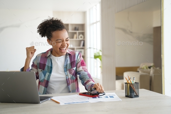 Excited mixed race teen girl student got good news email on laptop celebrates personal achievement