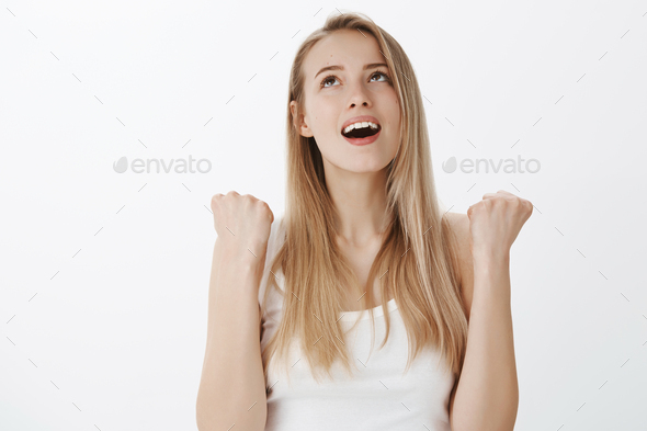 Relieved happy young woman with blond hair breathing out and yelling finally with satisfaction as ac