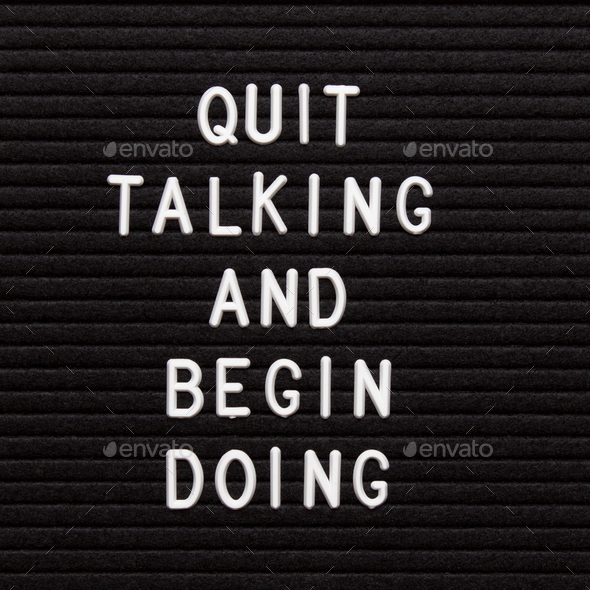 Motivational quote on black letter board. Quit talking and begin doing.