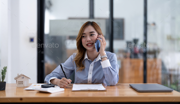 Smiling asian businesswoman, lawyer, real estate agent, banker or consultant making cell phone call