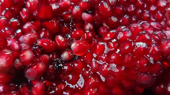 Super Close Up of Ripe Pomegranate Grains Falling Down with Juice alt