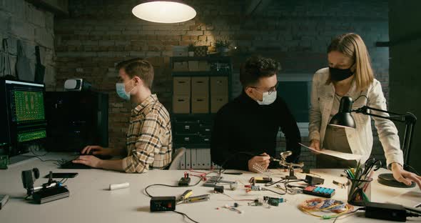 Team in Masks Work on Technology Electronics Startup in Loft Office at Night