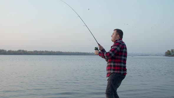 Fisherman Catching Fish in Lake at Dawn