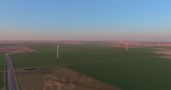 Wind Energy Blows Into West Texas Wind Turbine Farms in the Colorful Sunset Showing Renewable Energy alt