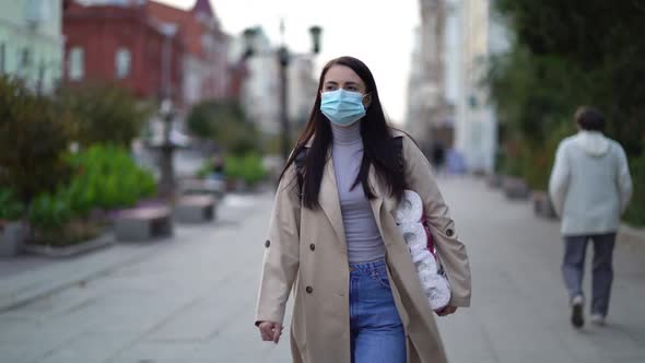 Women Walking in Medical Mask with Toilet Paper During the Second Wave Quarantine Coronavirus COVID alt