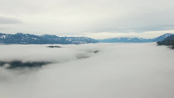 Aerial View of Canadian Mountain Landscape Covered in Fog Over Harrison Lake alt