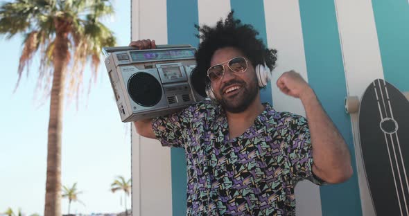 Young african american man dancing outdoor with vintage boombox - Party and summer lifestyle concept alt