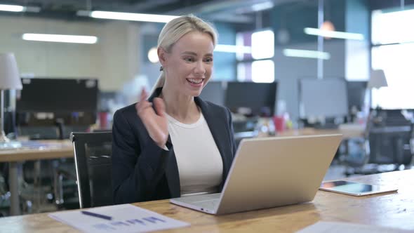 Cheerful Businesswoman Doing Video Chat on Laptop in Office alt