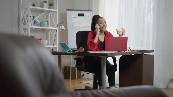 Wide Shot Portrait of Positive African American Young Woman Drinking Morning Cappuccino Talking on alt