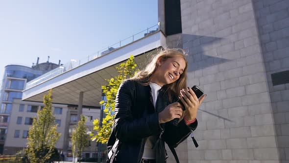 Attractive Young Caucasian Woman Using App on Smartphone and Browsing Texting alt