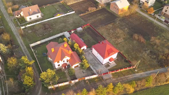 Aerial landscape of small town or village with rows of residential homes and green trees. alt