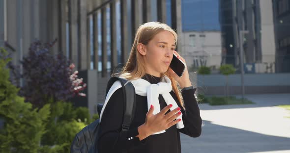 Blondie Has Pleasant Phone Conversation Outdoors Near Office Building alt