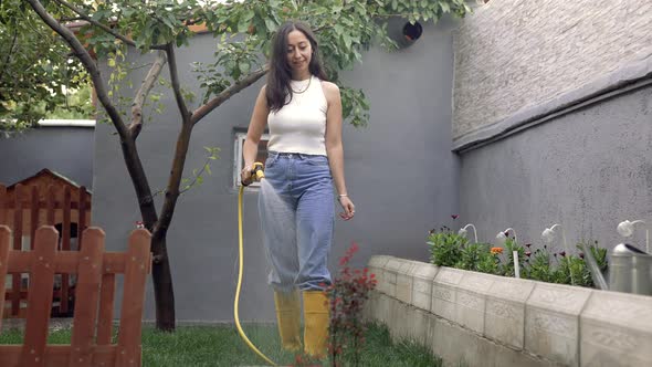 Woman Watering Lawn By Hose at Garden alt