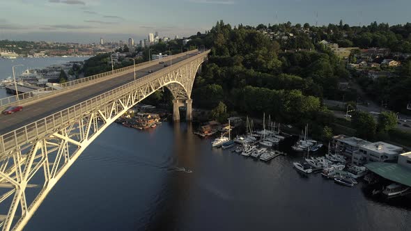 Rising Aerial Of Beautiful City Bridge With People Driving And Boating On Sunny Day