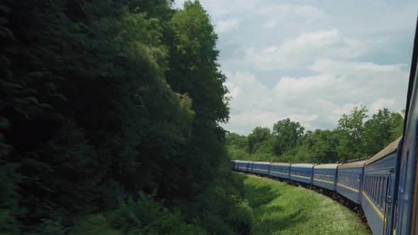 Side View of Highspeed Turning Train on Landscape of Beautiful Nature Wild Field and Mountains alt