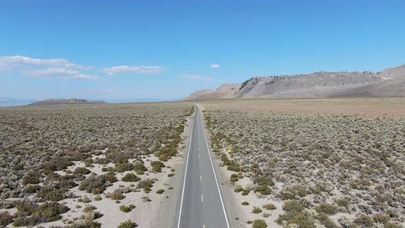 Aerial View of Asphalt Road in the Middle of Dusty Dry Desert Land in Lee Vining alt